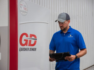 Dearing employee reviewing Gardner Denver machine