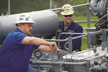 Service technicians fixing on-site compressor