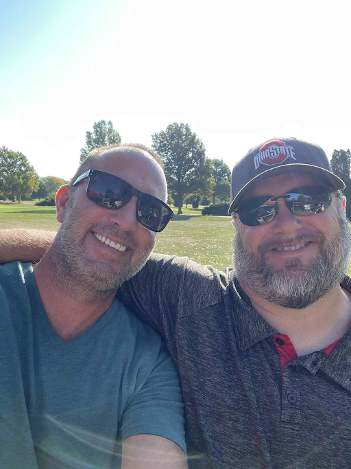 Two smiling golfers taking a selfie together during the company’s annual golf outing.
