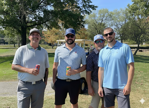 Four golfers smiling together in front of a golf cart at the annual company outing.